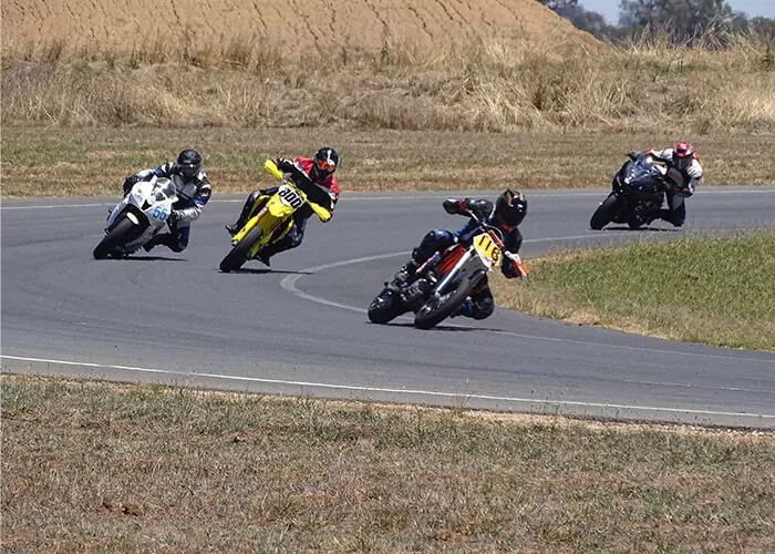 Track riders cornering at MVTC, demonstrating safe rider etiquette and predictable lines