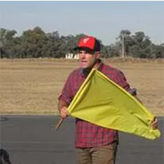 Flag marshal holding a yellow flag during rider briefing at Murray Valley Training Centre