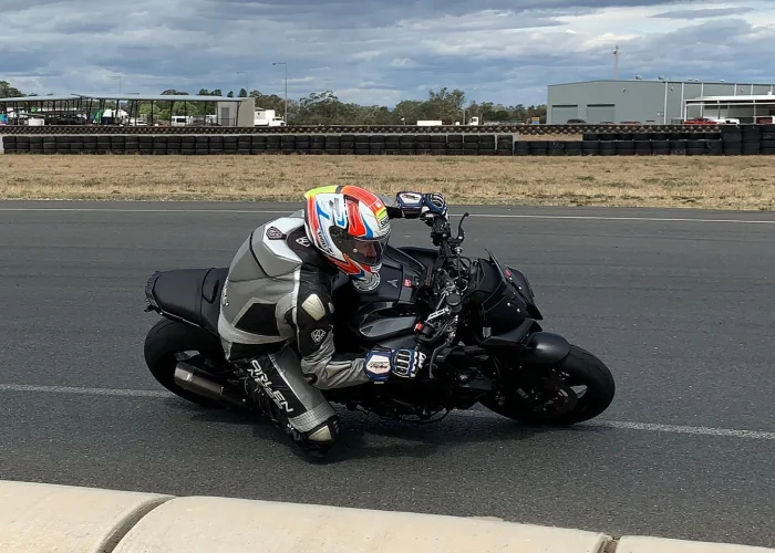 Motorcyclist on a black sportbike practising cornering technique at Murray Valley Training Centre